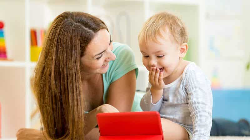 Mom and baby looking at screen together and laughing