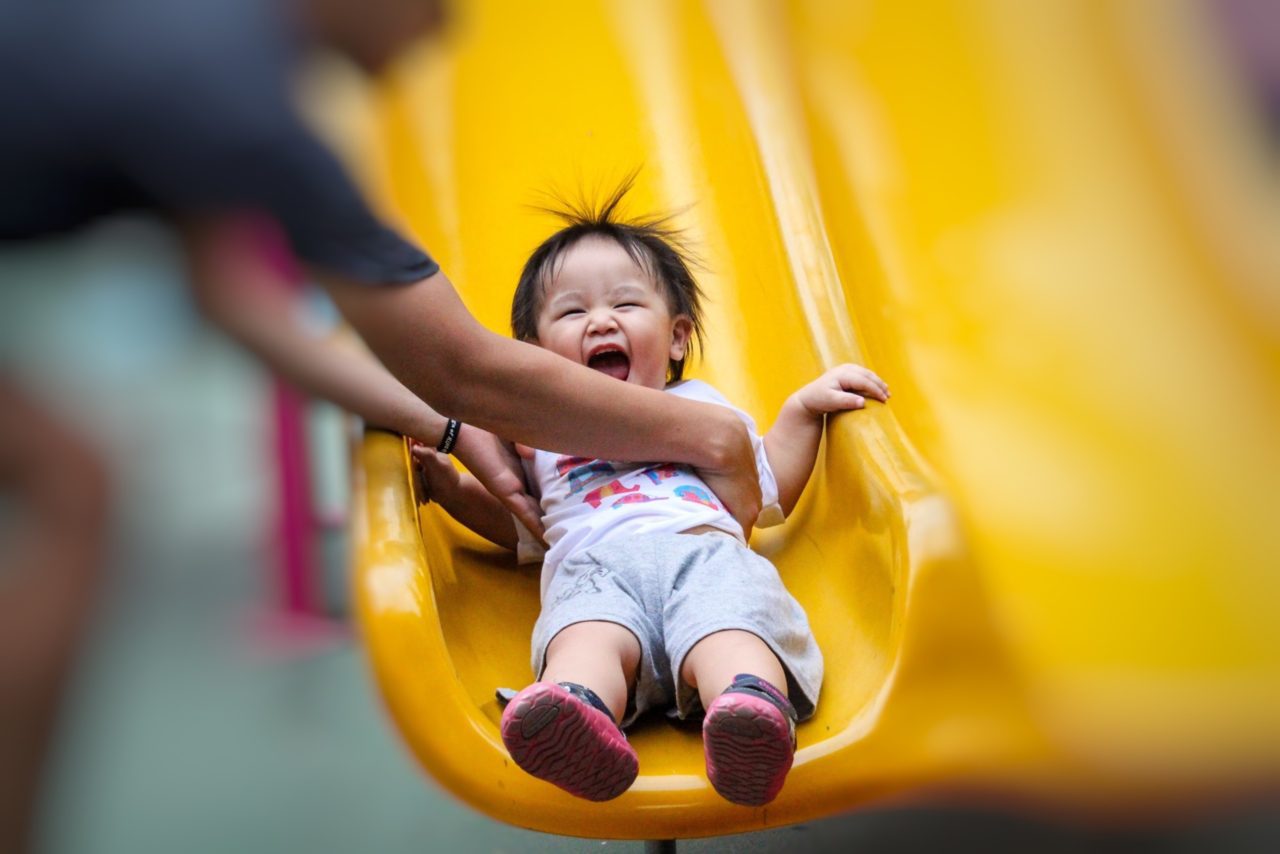 child laughing on slide
