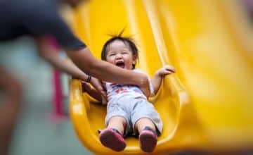 child laughing on slide