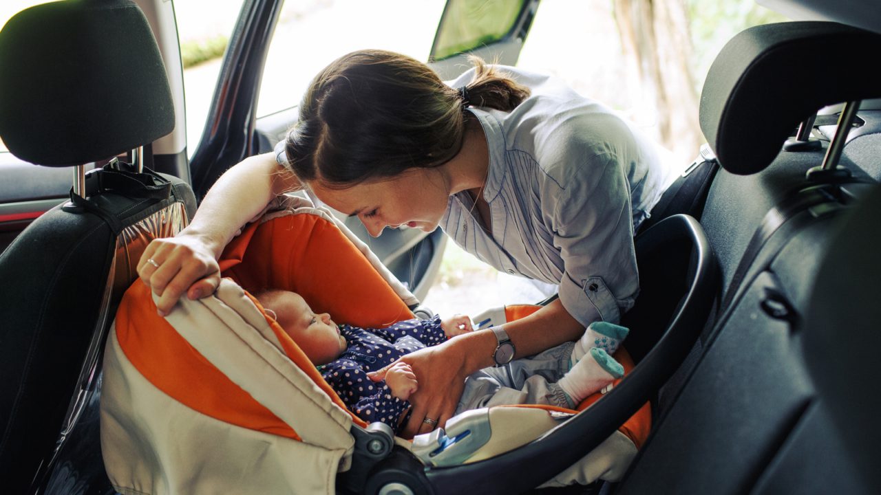 woman putting baby in carseat