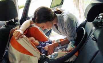 woman putting baby in carseat