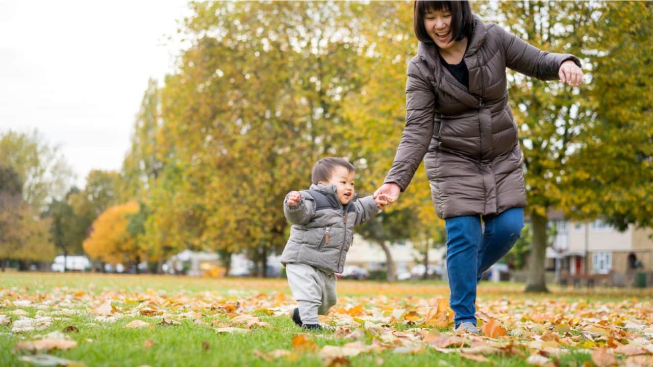 mother and son playing in leaves