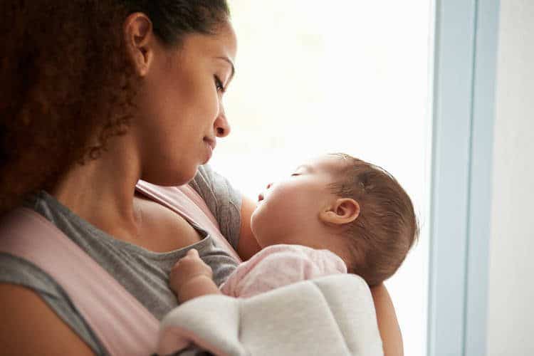 Mother holding a baby while they are sleeping