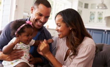 Parents with new baby smiling and laughing