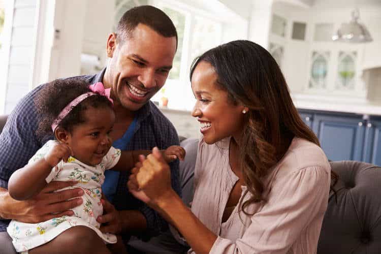 Parents with new baby smiling and laughing