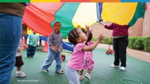 Child playing under parachute