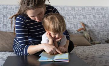 mom with dreads reading to toddler