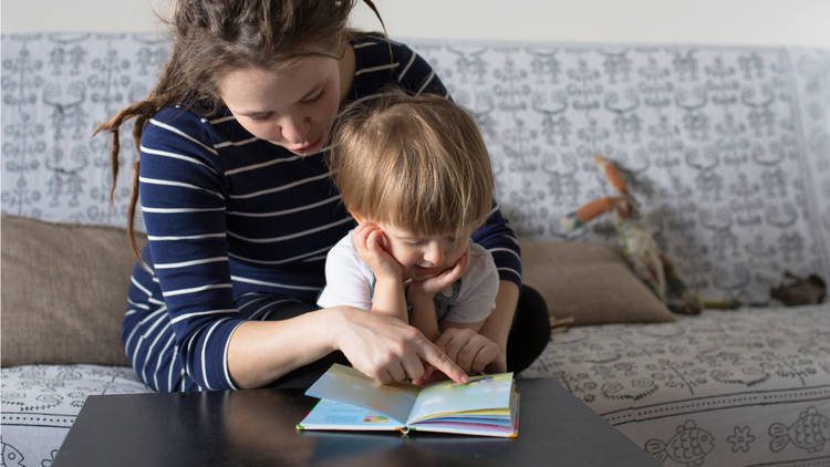 mom with dreads reading to toddler