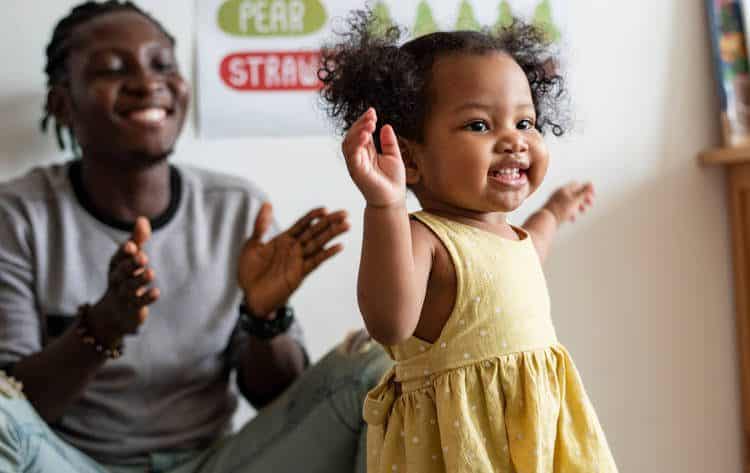 Father clapping while daughter walks