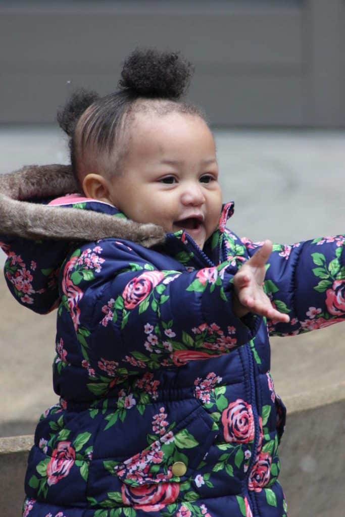 Child laughing and holding arms out