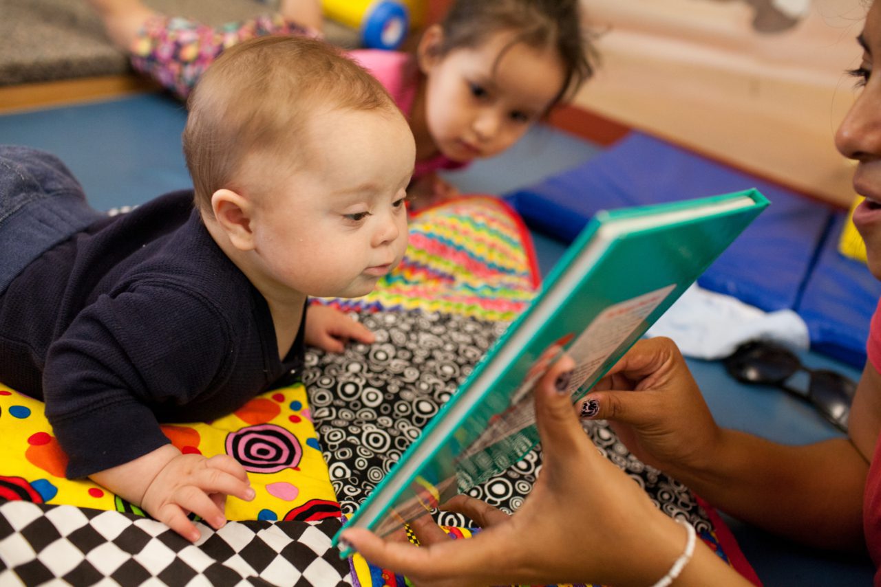 baby on stomach looking at book