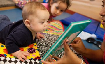 baby on stomach looking at book