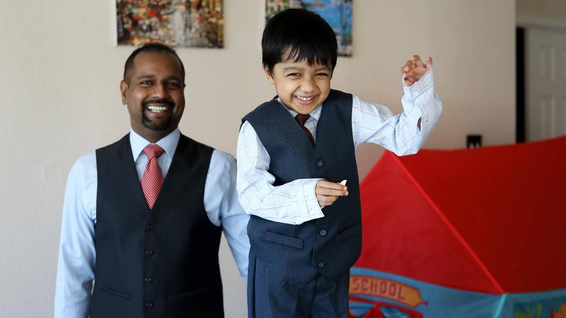 father and sun smiling in suits