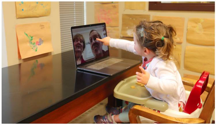 Toddler with grandparents on laptop