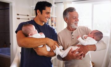 Father and grandfather holding newborn babies