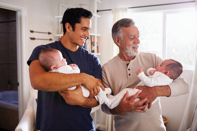 Father and grandfather holding newborn babies