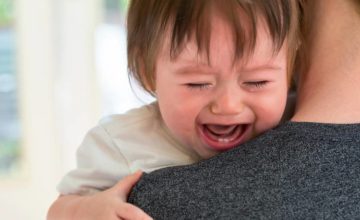 toddler crying and caregiver helping manage aggressive behavior
