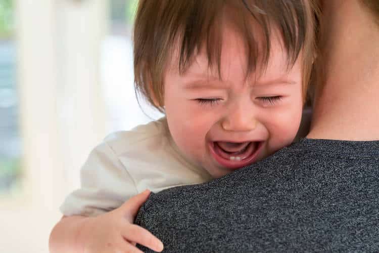 toddler crying and caregiver helping manage aggressive behavior