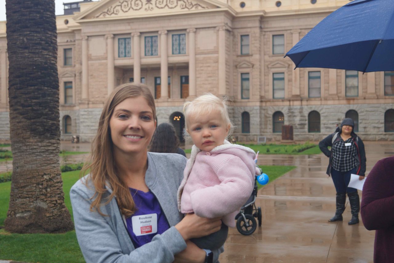 mom holding baby outside of arizona state capitol building