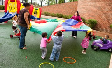daycare playing with big parachute