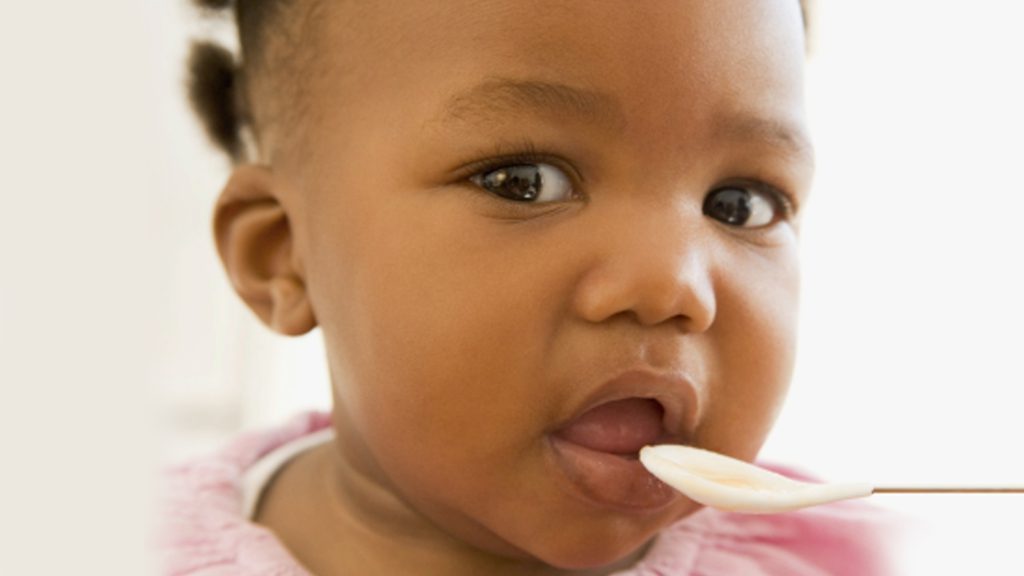 A child eating food off a spoon