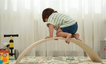 A child climbs and plays with toys