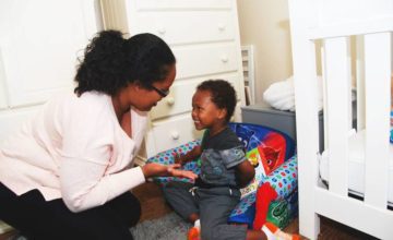 mother reaching out hand to smiling baby