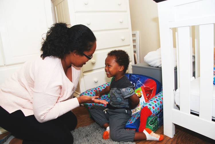 mother reaching out hand to smiling baby