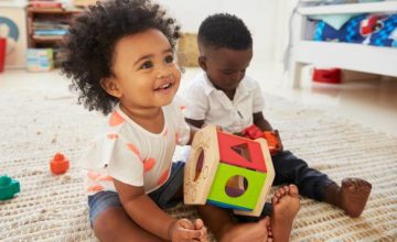 Two small children play with toys