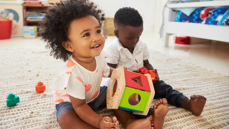 Two small children play with toys