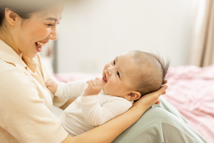 Asian mother and newborn baby feet are smiling and happy