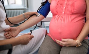 Nurse measuring pressure of pregnant woman