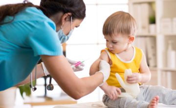 Female doctor makes a vaccination to a child