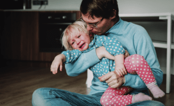 man comforting crying toddler