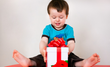 Toddler boy with a gift in his lap