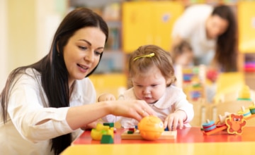 An early childhood educator interacts with a toddler
