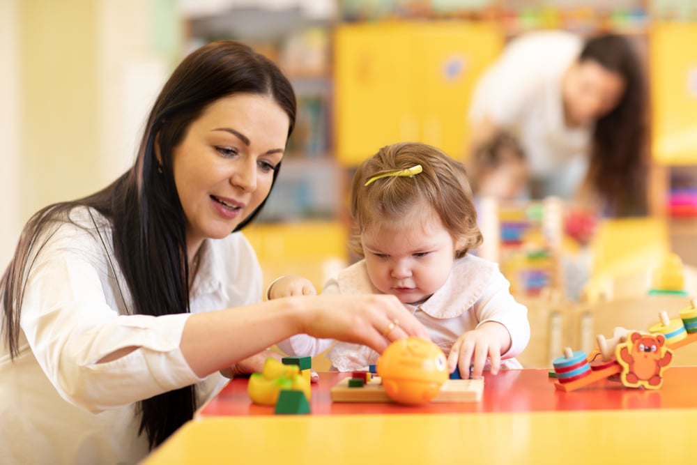 An early childhood educator interacts with a toddler