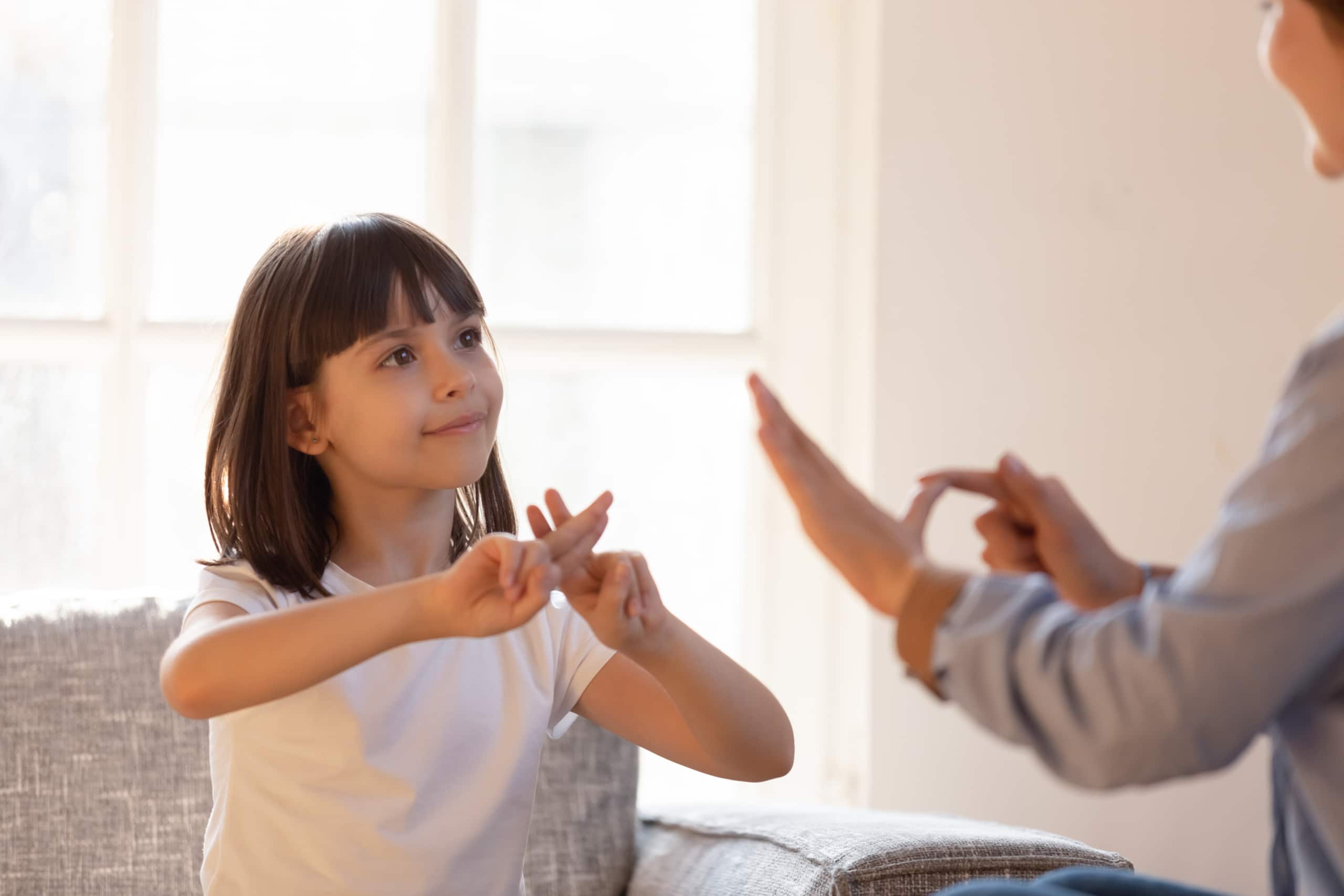 Girl signing to an adult, whose hands we see.