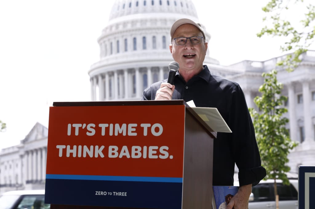 Matthew Melmed standing at a podium speaking in front of the Capitol building