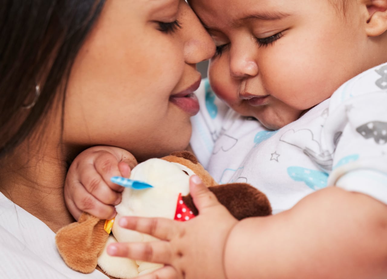 mother and baby snuggling with toy