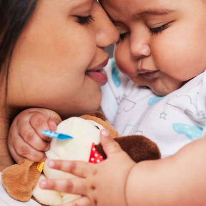 mother and baby snuggling with toy