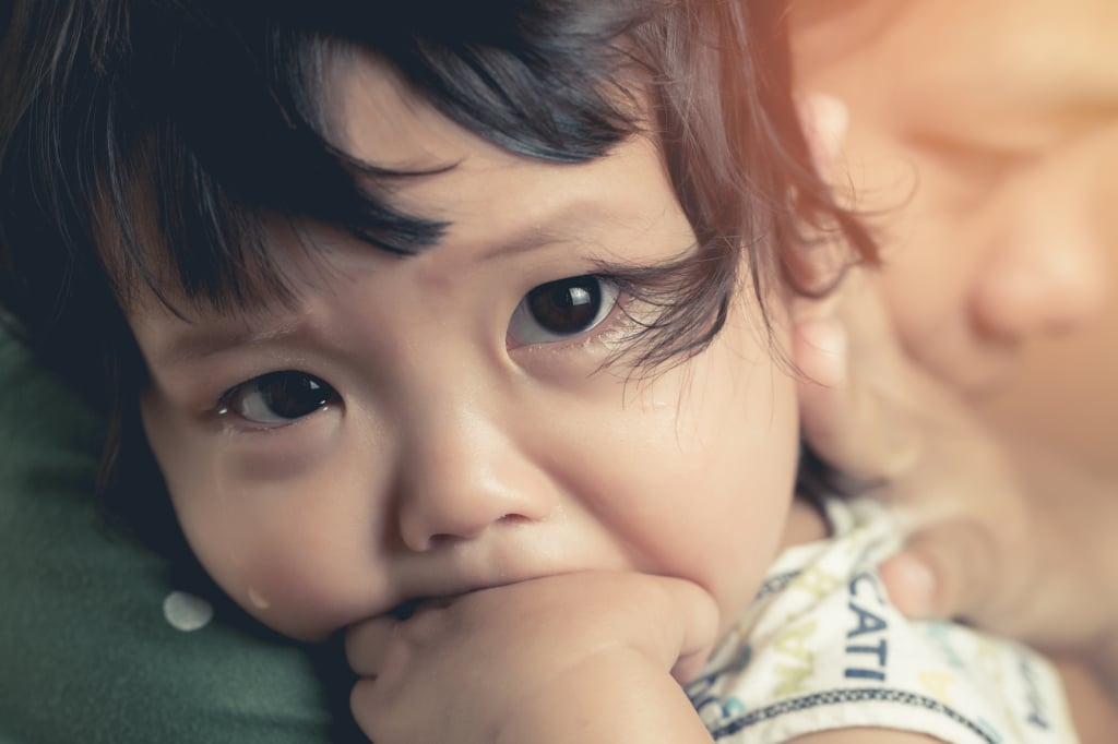 A young child being comforted by their caregiver
