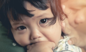A young child being comforted by their caregiver