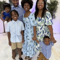 Ashley R. smiling with her family and Milo