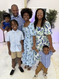 Ashley R. smiling with her family and Milo