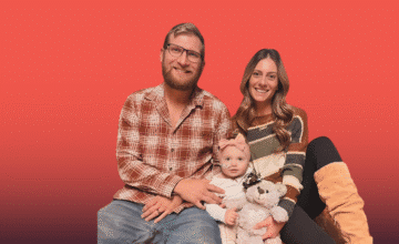 Ashley and her family sitting on the floor smiling