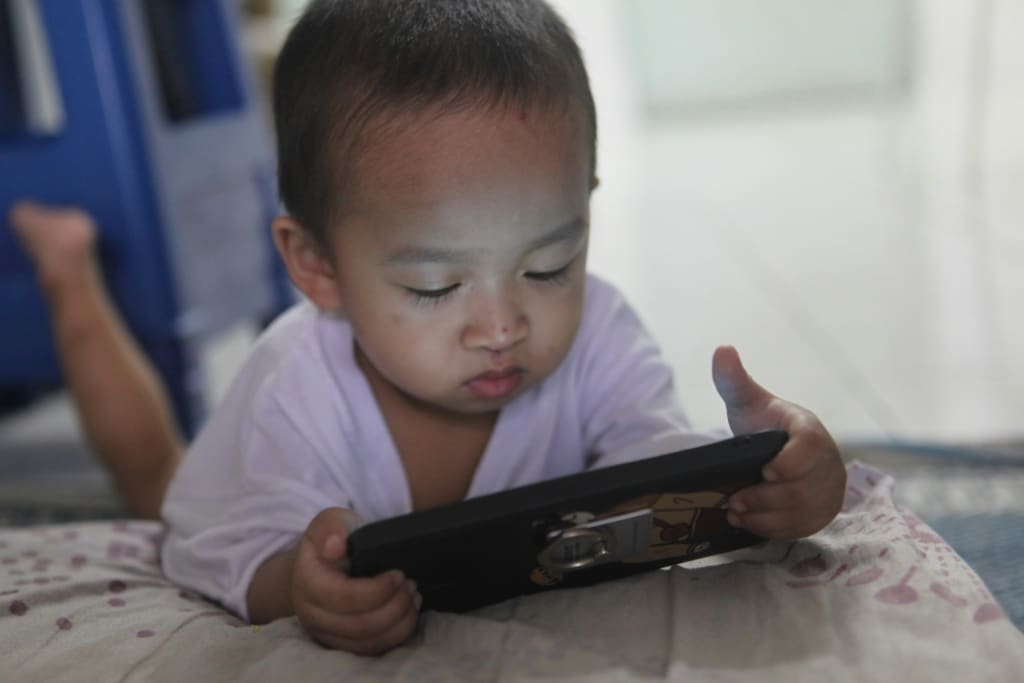 Young toddler looking at a phone