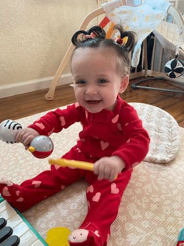 Bry's daughter holding a rattle