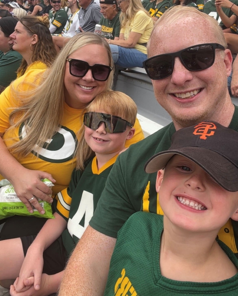 a woman and a man with two children at a sporting event