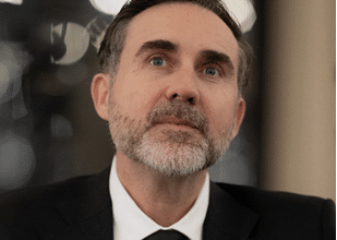 a man in a jacket with white shirt and a tie